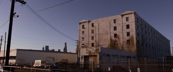 Movie still from “El Chicano” (2018), directed by Ben Hernandez Bray – An old building with a basketball hoop on the side of the building; Extreme Wide shot, Low angle