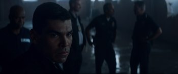 Movie still from “El Chicano” (2018), directed by Ben Hernandez Bray – A group of men standing next to each other in a dark room; Close Up shot, Over the shoulder angle