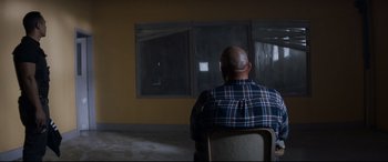 Movie still from “El Chicano” (2018), directed by Ben Hernandez Bray – A man sitting in a chair in front of a window; Wide shot, Over the shoulder angle