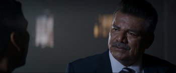 Movie still from “El Chicano” (2018), directed by Ben Hernandez Bray – A person wearing a suit and tie; Close Up shot, Over the shoulder angle