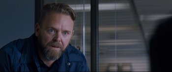 Movie still from “El Chicano” (2018), directed by Ben Hernandez Bray – A man with a goatee and a blue shirt; Close Up shot, Over the shoulder angle