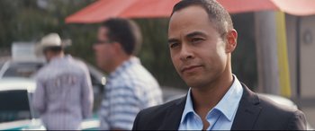 Movie still from “El Chicano” (2018), directed by Ben Hernandez Bray – A person wearing a suit and tie; Close Up shot, Over the shoulder angle