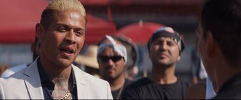 Movie still from “El Chicano” (2018), directed by Ben Hernandez Bray – A group of men standing next to each other on a street; Close Up shot, Over the shoulder angle