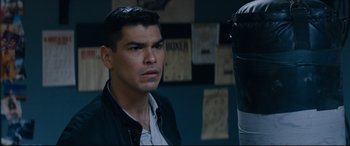 Movie still from “El Chicano” (2018), directed by Ben Hernandez Bray – A man in a black jacket is looking at the camera; Close Up shot, High angle
