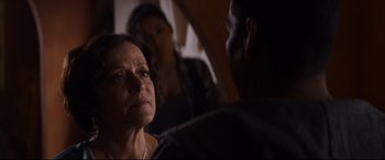 Movie still from “El Chicano” (2018), directed by Ben Hernandez Bray – An older woman looking at a younger man in a dark room; Close Up shot, Over the shoulder angle