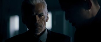 Movie still from “El Chicano” (2018), directed by Ben Hernandez Bray – An older man in a suit and tie looking at the camera; Close Up shot, Over the shoulder angle