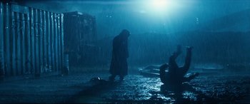 Movie still from “El Chicano” (2018), directed by Ben Hernandez Bray – A man in a raincoat standing in the middle of a flooded area; Wide shot, Low angle
