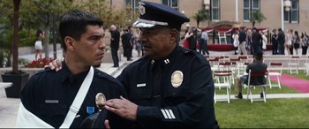 Movie still from “El Chicano” (2018), directed by Ben Hernandez Bray – A police officer talking to another police officer outside; Medium shot, Over the shoulder angle