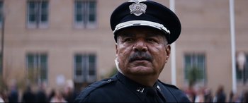 Movie still from “El Chicano” (2018), directed by Ben Hernandez Bray – A man in a police officer's uniform; Close Up shot, Low angle