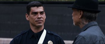 Movie still from “El Chicano” (2018), directed by Ben Hernandez Bray – A police officer is standing next to another officer; Close Up shot, Over the shoulder angle