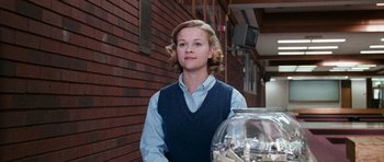 Movie still from “Election” (1999), directed by Alexander Payne – A woman standing in front of a fish bowl; Medium shot, Low angle