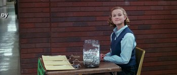 Movie still from “Election” (1999), directed by Alexander Payne – A young girl sitting at a table with a jar of water; Medium shot, Low angle