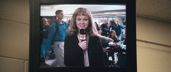 Movie still from “Election” (1999), directed by Alexander Payne – A woman holding a microphone in front of a crowd; Medium shot, Over the shoulder angle