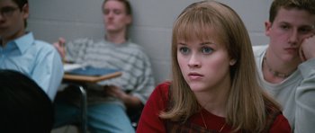 Movie still from “Election” (1999), directed by Alexander Payne – A woman sitting in front of a man in a room; Close Up shot, Low angle