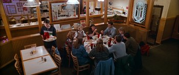 Movie still from “Election” (1999), directed by Alexander Payne – A group of people sitting around a table at a restaurant; Wide shot, High angle