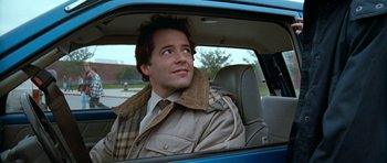 Movie still from “Election” (1999), directed by Alexander Payne – A man sitting in the passenger seat of a blue car; Close Up shot, Over the shoulder angle