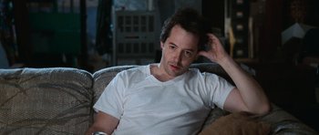 Movie still from “Election” (1999), directed by Alexander Payne – A man sitting on top of a couch in a living room; Close Up shot, High angle