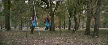Movie still from “Election” (1999), directed by Alexander Payne – Two children are playing on a swing set in a park; Wide shot, High angle