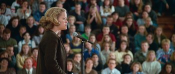Movie still from “Election” (1999), directed by Alexander Payne – A woman standing at a microphone in front of an audience; Medium shot, Low angle