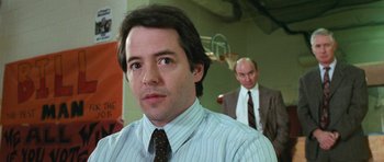 Movie still from “Election” (1999), directed by Alexander Payne – A man in a suit and tie standing next to another man in a suit and tie; Close Up shot, Over the shoulder angle
