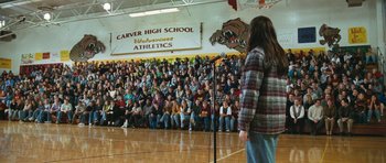 Movie still from “Election” (1999), directed by Alexander Payne – A crowd of people sitting in front of a microphone; Wide shot, High angle