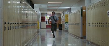 Movie still from “Election” (1999), directed by Alexander Payne – A man running down a hallway in a school; Wide shot, High angle