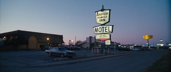 Movie still from “Election” (1999), directed by Alexander Payne – An old motel sign is lit up at night; Wide shot, High angle
