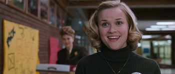 Movie still from “Election” (1999), directed by Alexander Payne – A person smiling at the camera; Close Up shot, Low angle