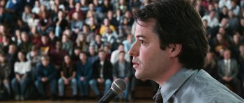 Movie still from “Election” (1999), directed by Alexander Payne – A man with a microphone in front of an audience; Close Up shot, Over the shoulder angle