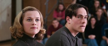 Movie still from “Election” (1999), directed by Alexander Payne – A woman and a man sitting next to each other in a room; Close Up shot, Low angle