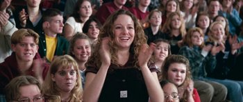 Movie still from “Election” (1999), directed by Alexander Payne – A woman clapping in front of a group of people; Medium shot, High angle