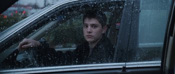Movie still from “Election” (1999), directed by Alexander Payne – A man sitting in the drivers seat of a car in the rain; Close Up shot, Over the shoulder angle