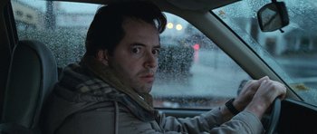 Movie still from “Election” (1999), directed by Alexander Payne – A man sitting in the drivers seat of a car in the rain; Close Up shot, Low angle
