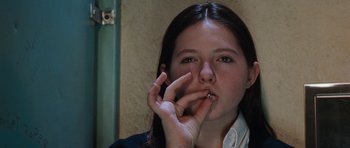 Movie still from “Election” (1999), directed by Alexander Payne – A young girl smoking a cigarette while holding her hand to her mouth; Close Up shot, Overhead angle