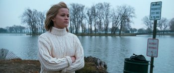 Movie still from “Election” (1999), directed by Alexander Payne – A woman standing in front of a body of water with her arms crossed; Medium shot, Low angle