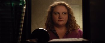Movie still from “Dumplin'” (2018), directed by Anne Fletcher – A person with curly hair looking into a mirror; Close Up shot, Over the shoulder angle