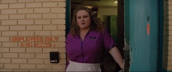 Movie still from “Dumplin'” (2018), directed by Anne Fletcher – A woman standing in front of a brick wall; Medium shot, Low angle
