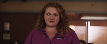 Movie still from “Dumplin'” (2018), directed by Anne Fletcher – A woman with curly hair wearing a purple jacket; Close Up shot, Over the shoulder angle