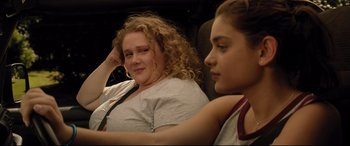 Movie still from “Dumplin'” (2018), directed by Anne Fletcher – A woman sitting next to another woman in a car; Close Up shot, Over the shoulder angle