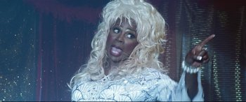 Movie still from “Dumplin'” (2018), directed by Anne Fletcher – A woman in a white dress and blonde wig; Close Up shot, Low angle