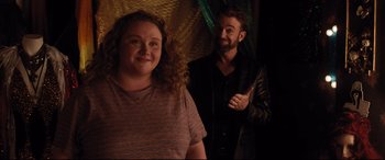 Movie still from “Dumplin'” (2018), directed by Anne Fletcher – A man and a woman standing next to each other in a room; Medium shot, Over the shoulder angle