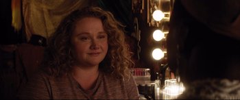 Movie still from “Dumplin'” (2018), directed by Anne Fletcher – A woman with curly red hair sitting in front of a mirror; Close Up shot, Over the shoulder angle