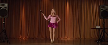 Movie still from “Dumplin'” (2018), directed by Anne Fletcher – A woman standing on a stage holding a clarinet; Medium shot, Low angle