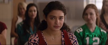 Movie still from “Dumplin'” (2018), directed by Anne Fletcher – A young woman wearing a floral shirt and a necklace; Close Up shot, Over the shoulder angle