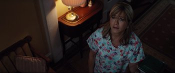 Movie still from “Dumplin'” (2018), directed by Anne Fletcher – A woman standing in front of a lamp in a room; Close Up shot, High angle