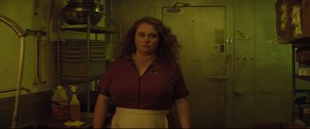 Movie still from “Dumplin'” (2018), directed by Anne Fletcher – A woman standing in a kitchen wearing an apron; Medium shot, Low angle