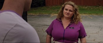 Movie still from “Dumplin'” (2018), directed by Anne Fletcher – A woman in a purple shirt standing in a parking lot; Close Up shot, Over the shoulder angle