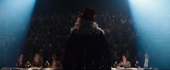 Movie still from “Dumplin'” (2018), directed by Anne Fletcher – A person wearing a red hat standing in front of an audience; Medium shot, Over the shoulder angle