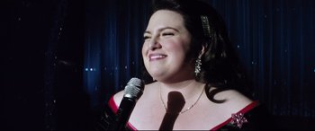 Movie still from “Dumplin'” (2018), directed by Anne Fletcher – A woman in a red dress is holding a microphone; Close Up shot, Low angle