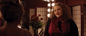 Movie still from “Dumplin'” (2018), directed by Anne Fletcher – A woman in a dressing room wearing a red sequined dress; Medium shot, Over the shoulder angle